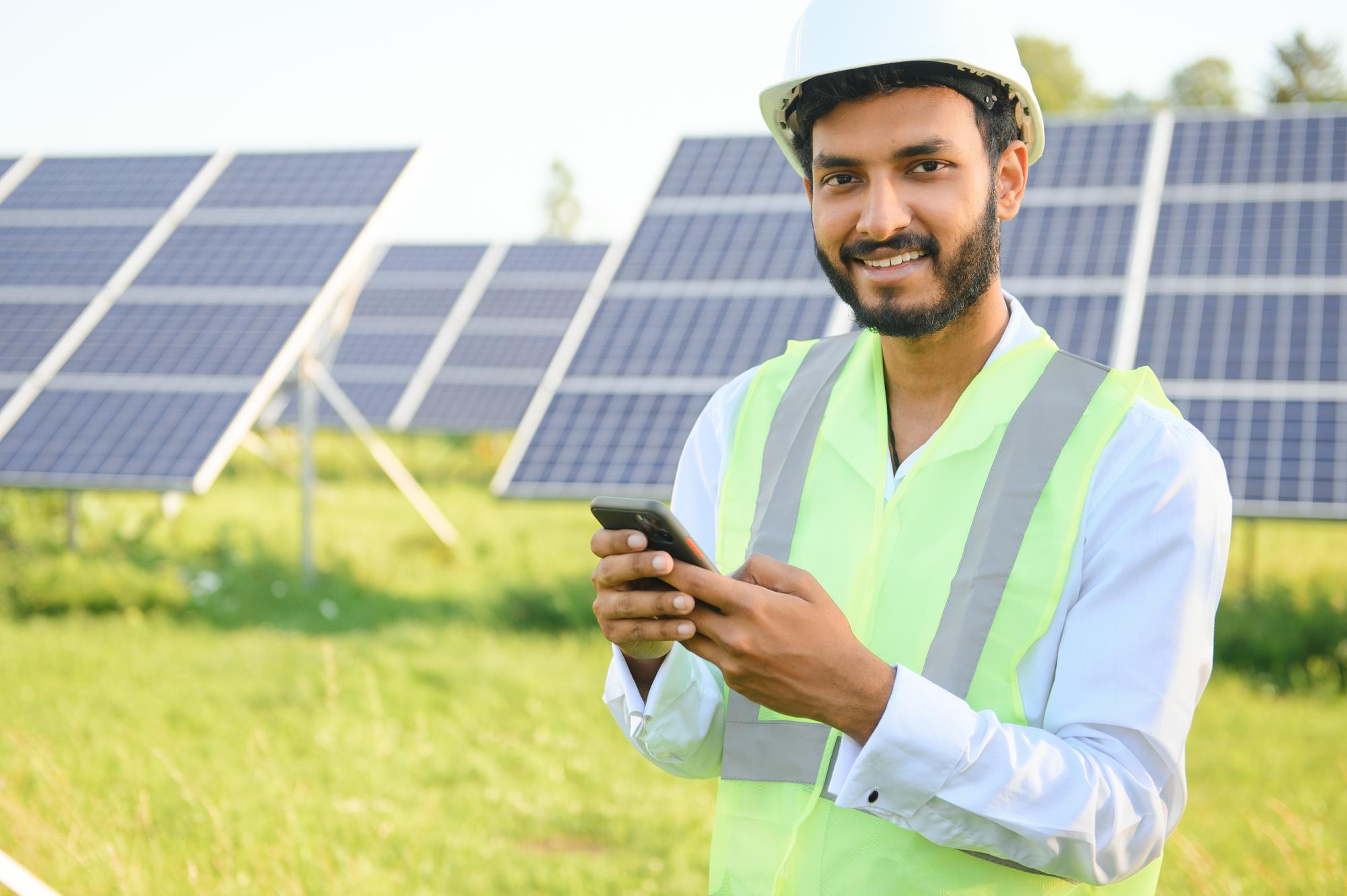 portrait-young-indian-technician-manager-wearing-formal-cloths-standing-with-solar-panel-renewable-energy-man-standing-crossed-arm-copy-space